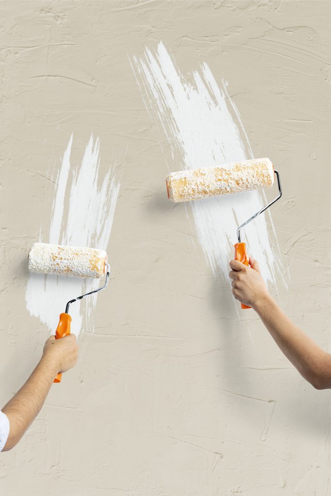 two hands painting the wall
