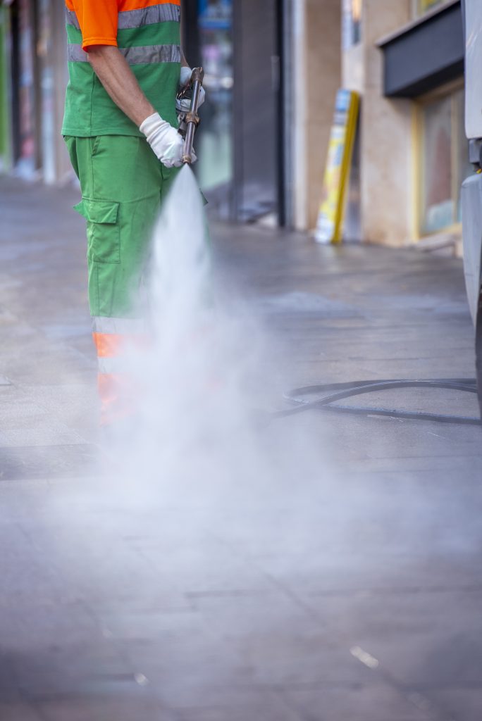 person cleaning streets with a pressure gun