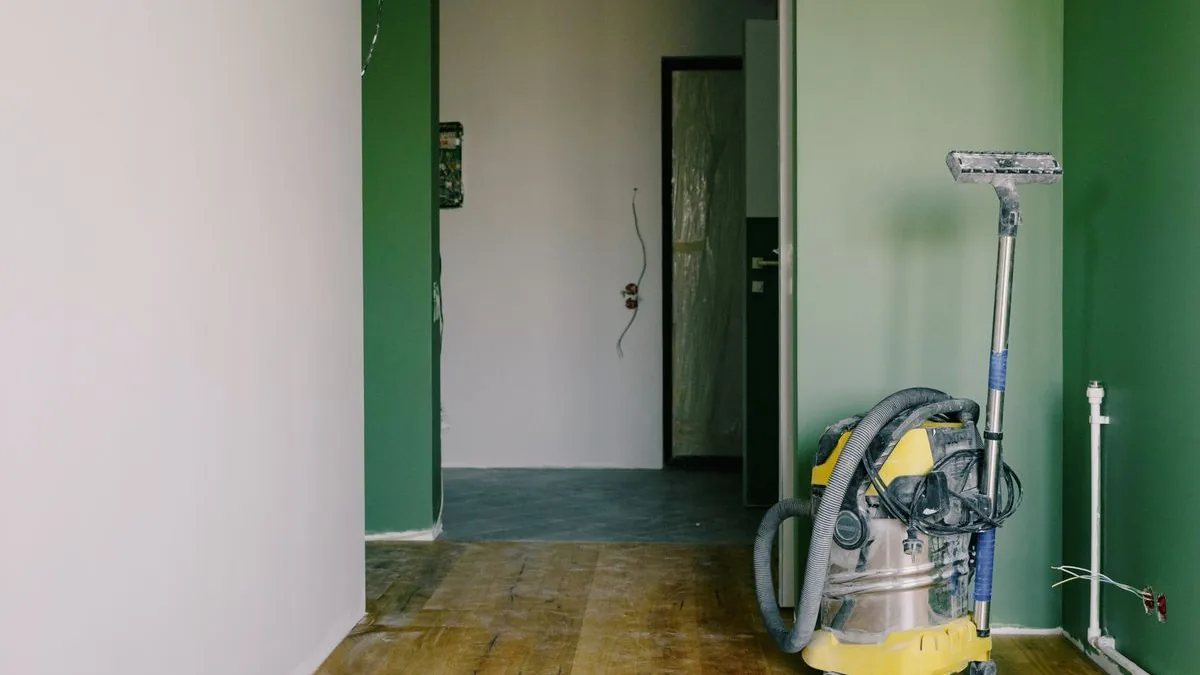 Aspirateur de chantier et raclette dans un logement en fin de travaux, fils électriques encore apparents
