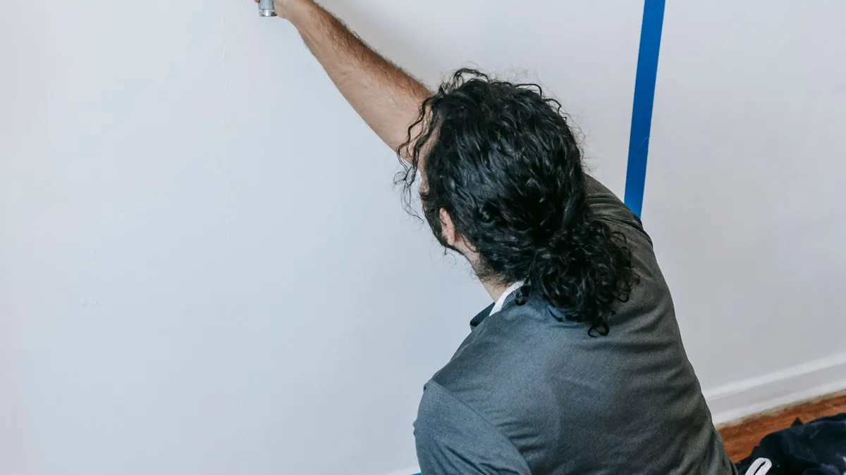 Mise en peinture d'un mur intérieur, adhésif de masquage posé le long de l'angle